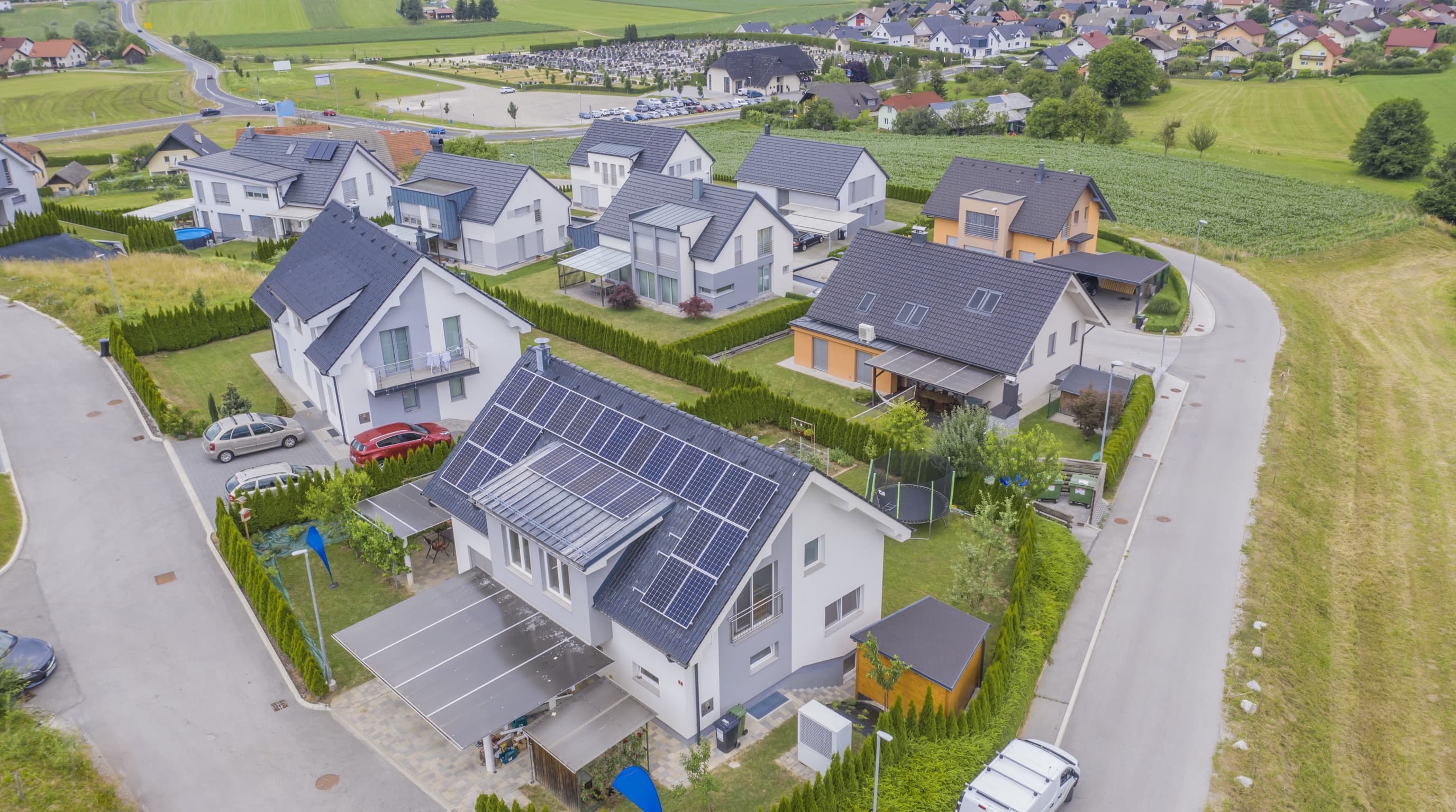 Vue aérienne d'un quartier résidentiel français dont de nombreuses toitures sont équipées de panneaux solaires, image symbolisant la souveraineté énergétique construite par les particuliers